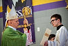 Archbishop Samuel J. Aquila holding his golden cane while reading at Mass