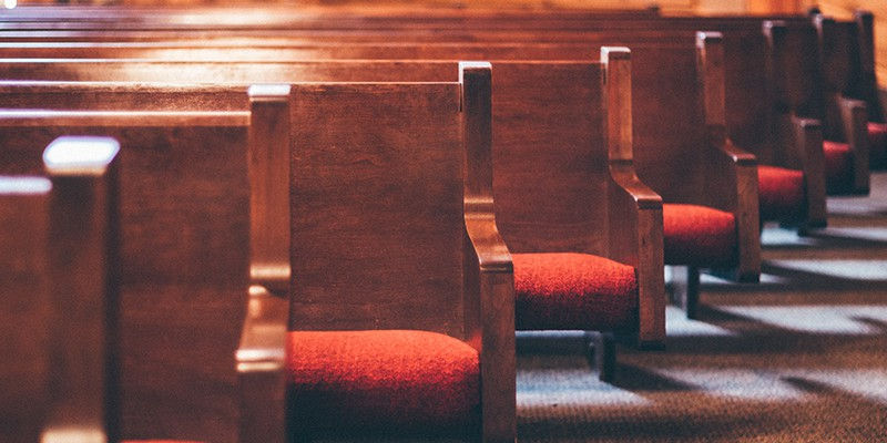 Wooden pews with red cushions