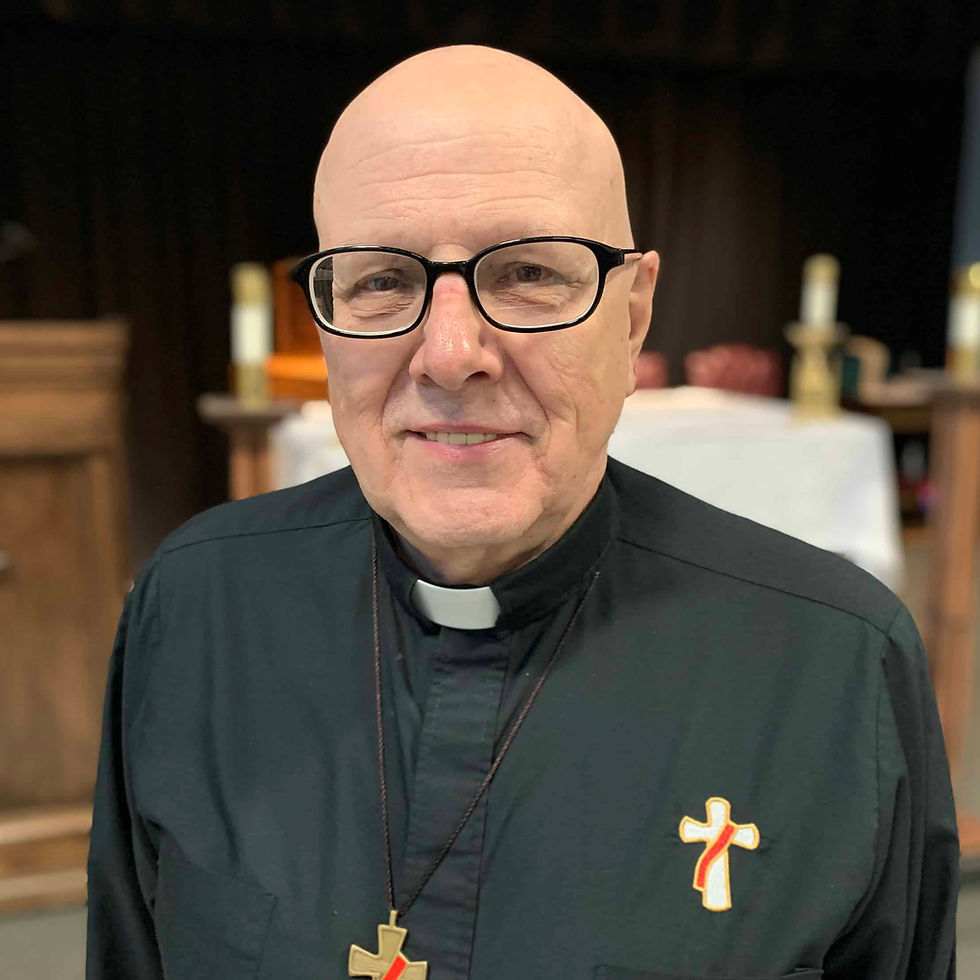 A priest in a green cassock smiling